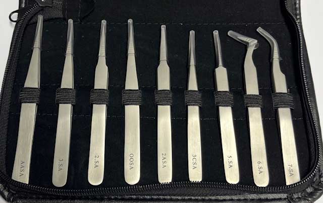 Set of 9 tweezers with black straps in a black case